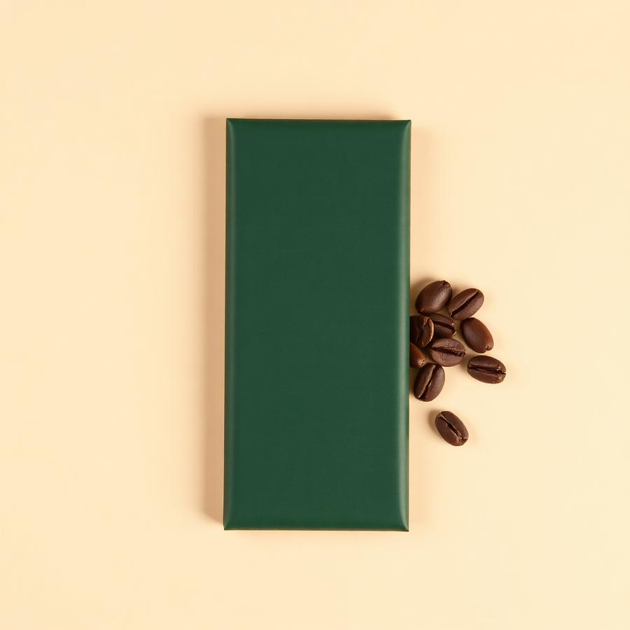 Dark chocolate bar in a matte forest green wrapper with cocoa beans